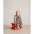 Baby sidder på to brændt orange Modu skamler på trægulv.